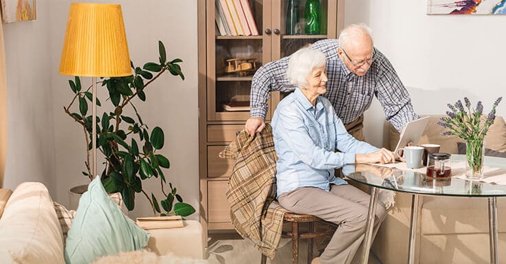 Seniorenpaar im Wohnzimmer mit einem Tablet